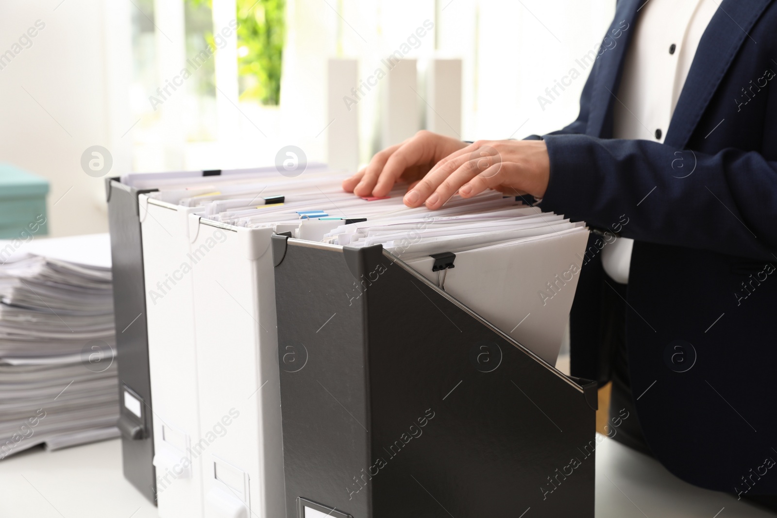 Photo of Woman taking documents from folder in archive, closeup