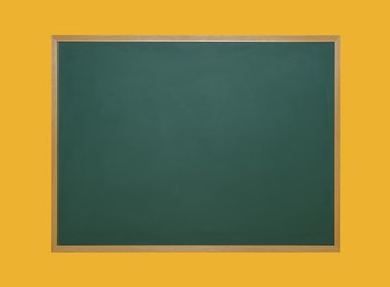 Clean green chalkboard on orange background. School equipment