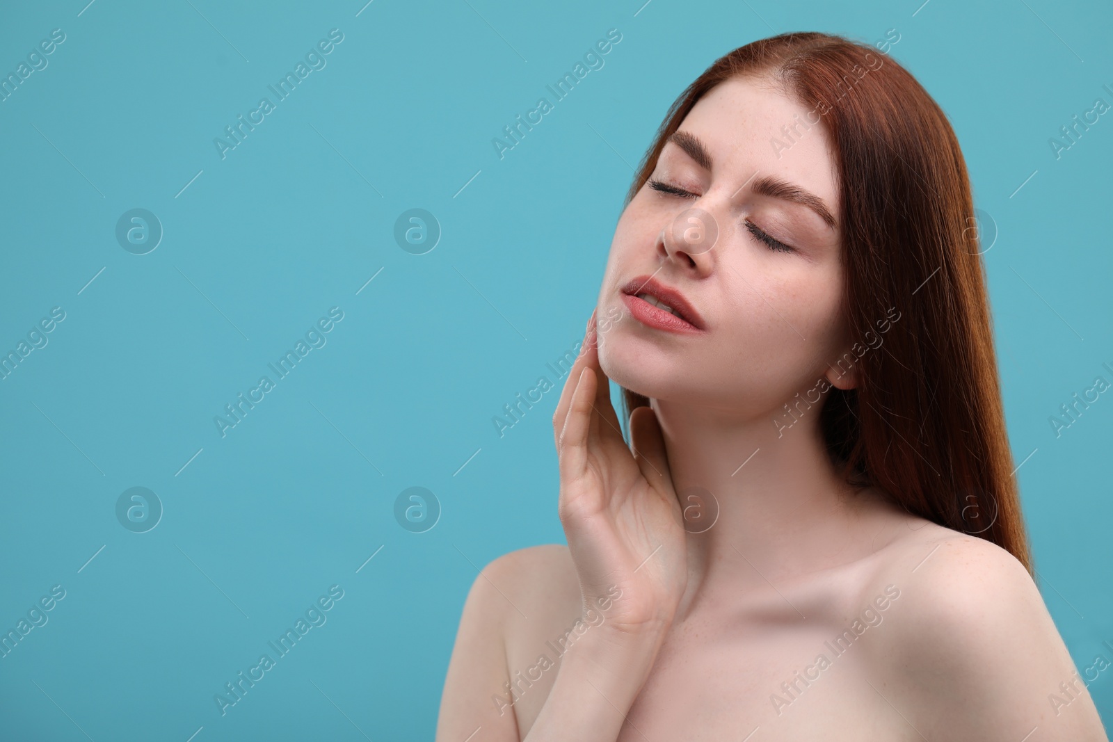 Photo of Portrait of beautiful woman with freckles on light blue background. Space for text