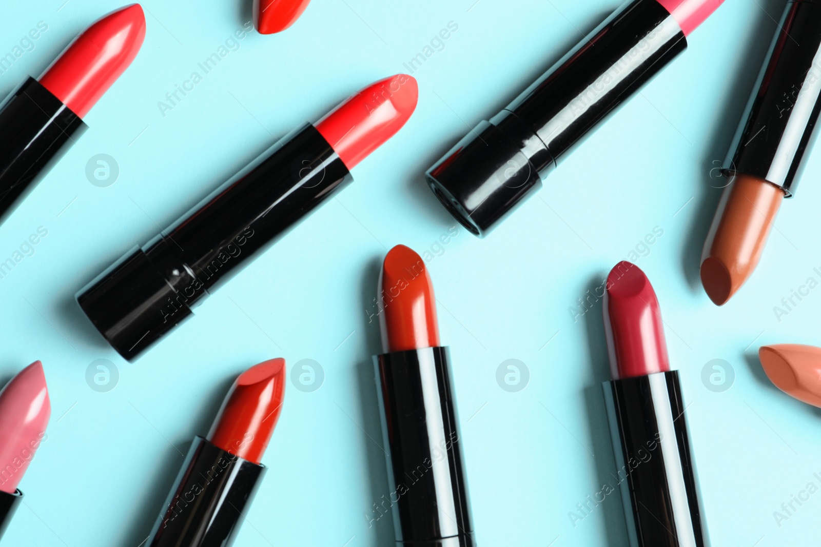 Photo of Flat lay composition with lipsticks on color background