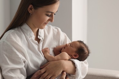 Photo of Mother holding her cute newborn baby indoors