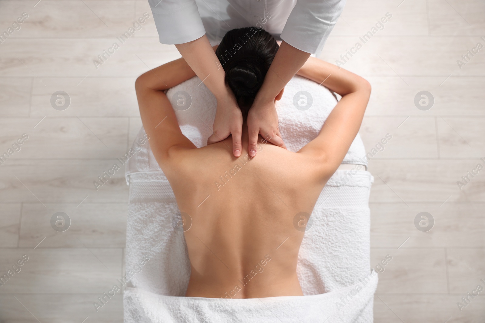 Photo of Beautiful woman receiving back massage in beauty salon, closeup. Top view