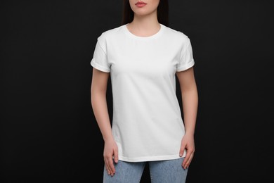 Photo of Woman wearing white t-shirt on black background, closeup