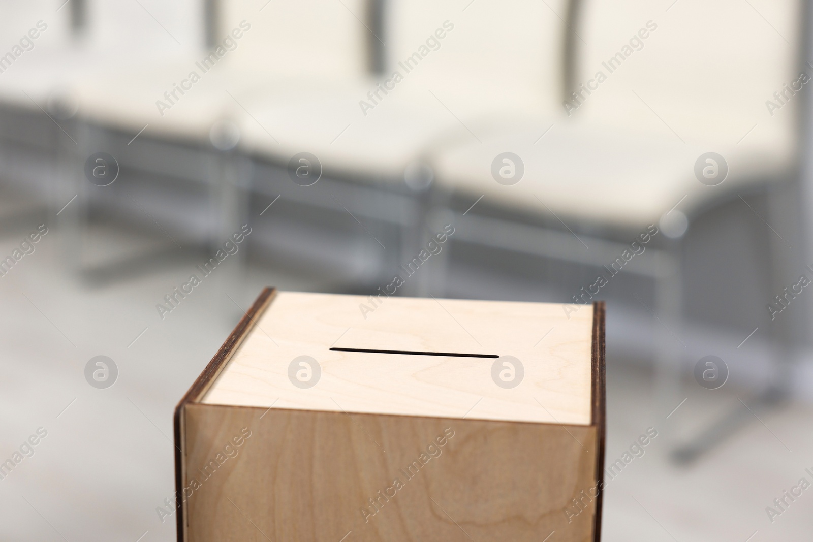 Photo of Wooden ballot box on blurred background, closeup. Space for text