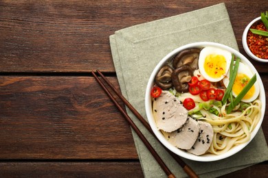 Photo of Delicious ramen with meat in bowl served on wooden table, flat lay. Space for text. Noodle soup