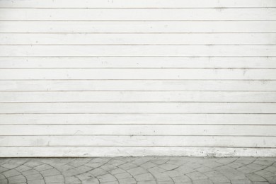 Photo of View on urban white wooden wall and pavement