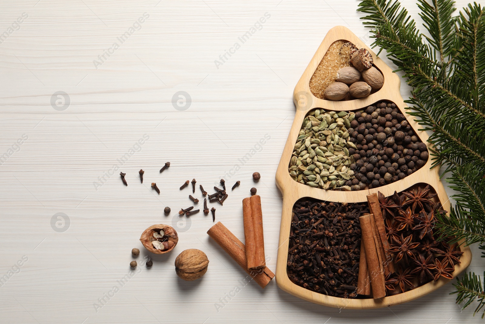 Photo of Different spices, nuts and fir branches on white wooden table, flat lay. Space for text