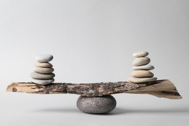 Photo of Tree branch with stones on grey background. Harmony and balance concept