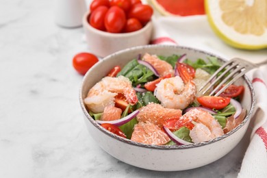 Delicious pomelo salad with shrimps served on white marble table, closeup. Space for text