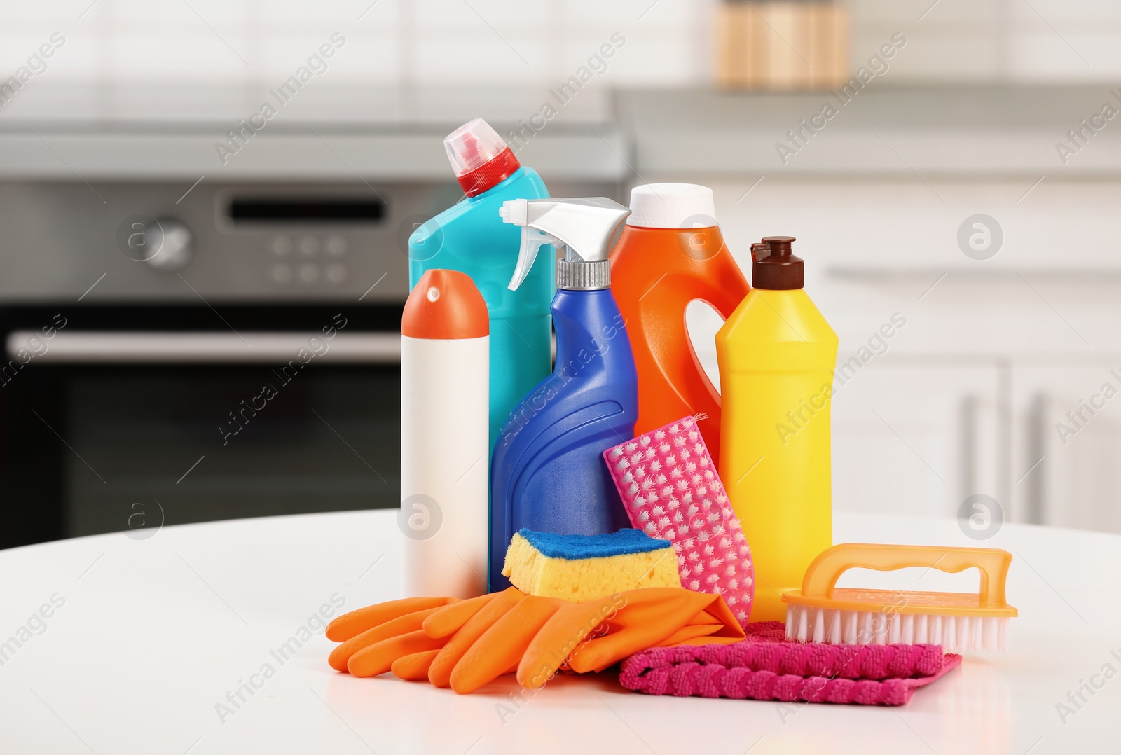 Photo of Set of cleaning supplies on table in kitchen