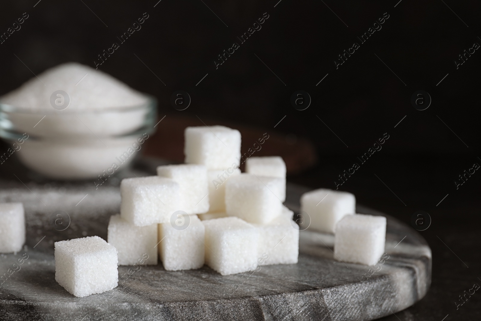 Photo of Heap of refined sugar cubes on black background