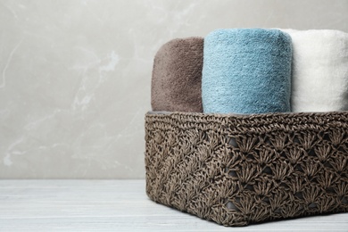 Photo of Basket of fresh towels on table. Space for text