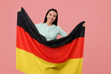 Photo of Happy young woman with flag of Germany on pink background