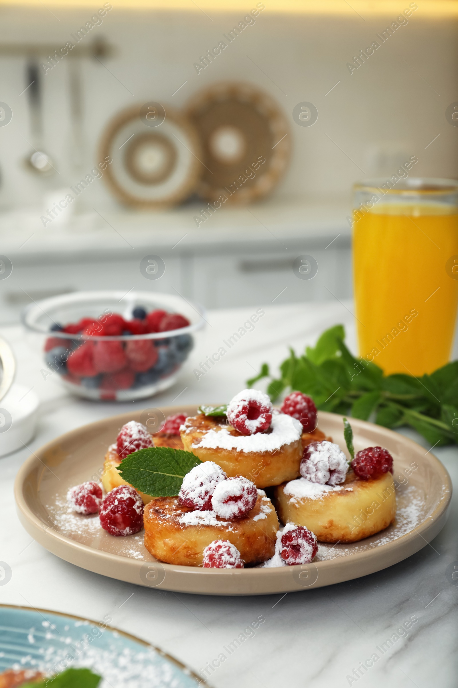 Photo of Delicious cottage cheese pancakes with fresh raspberries, mint and icing sugar on white table