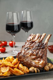 Photo of Delicious grilled ribs served on light grey table