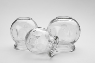 Photo of Glass cups on light grey background, closeup. Cupping therapy