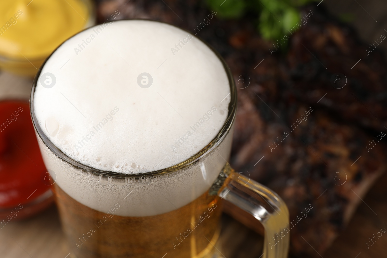 Photo of Glass mug with tasty beer on table, closeup. Space for text