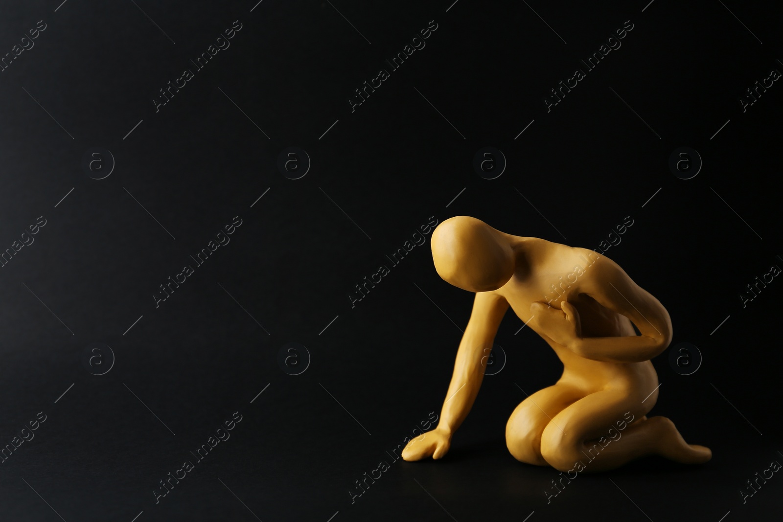 Photo of Plasticine figure of human asking help on black background. Space for text