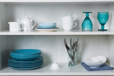 White shelving unit with set of dishware