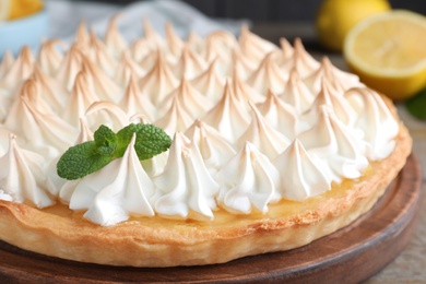 Photo of Delicious lemon meringue pie decorated with mint on table, closeup