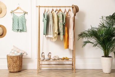 Photo of Modern room with clothes rack and houseplant. Interior design