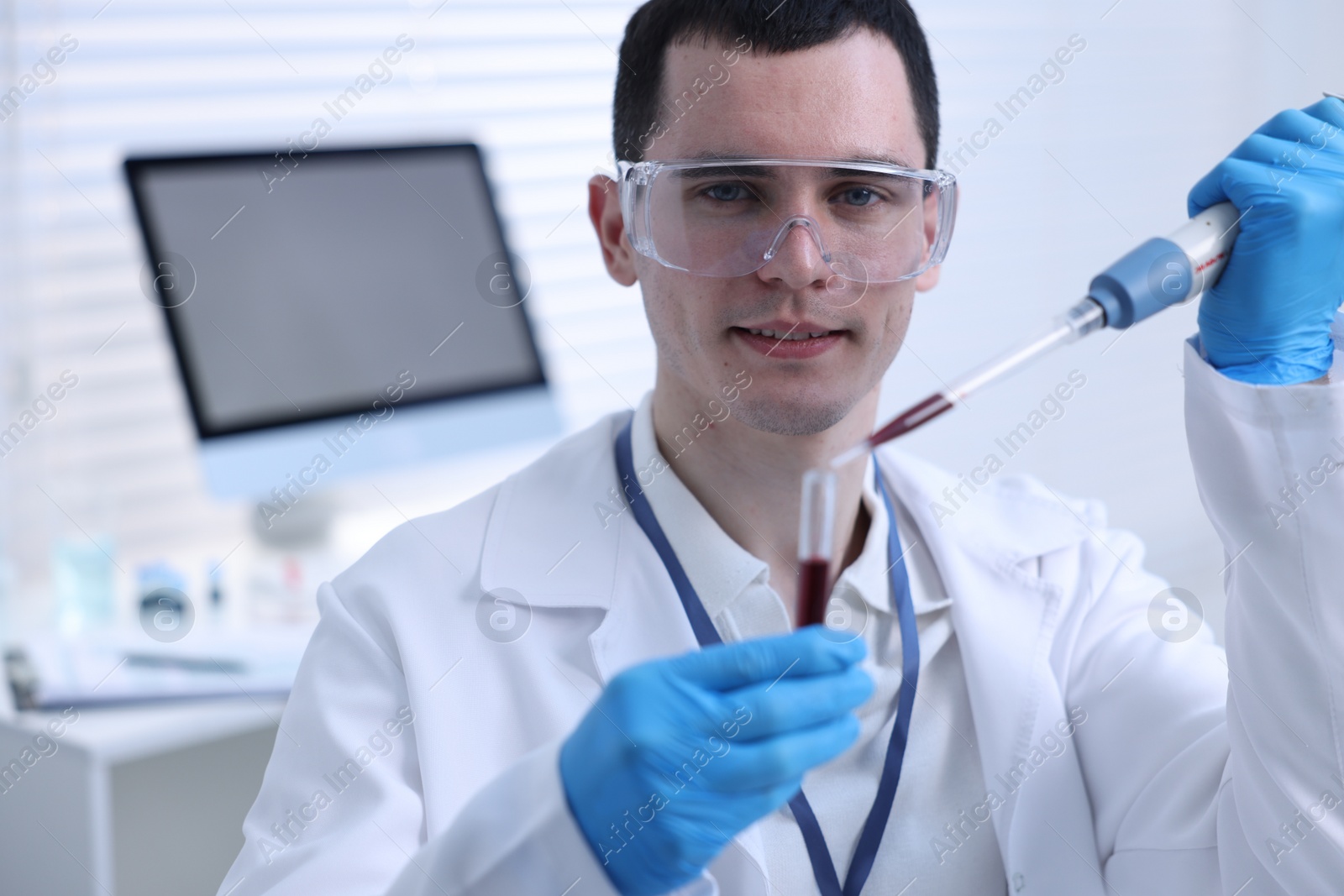 Photo of Scientist dripping sample into test tube in laboratory