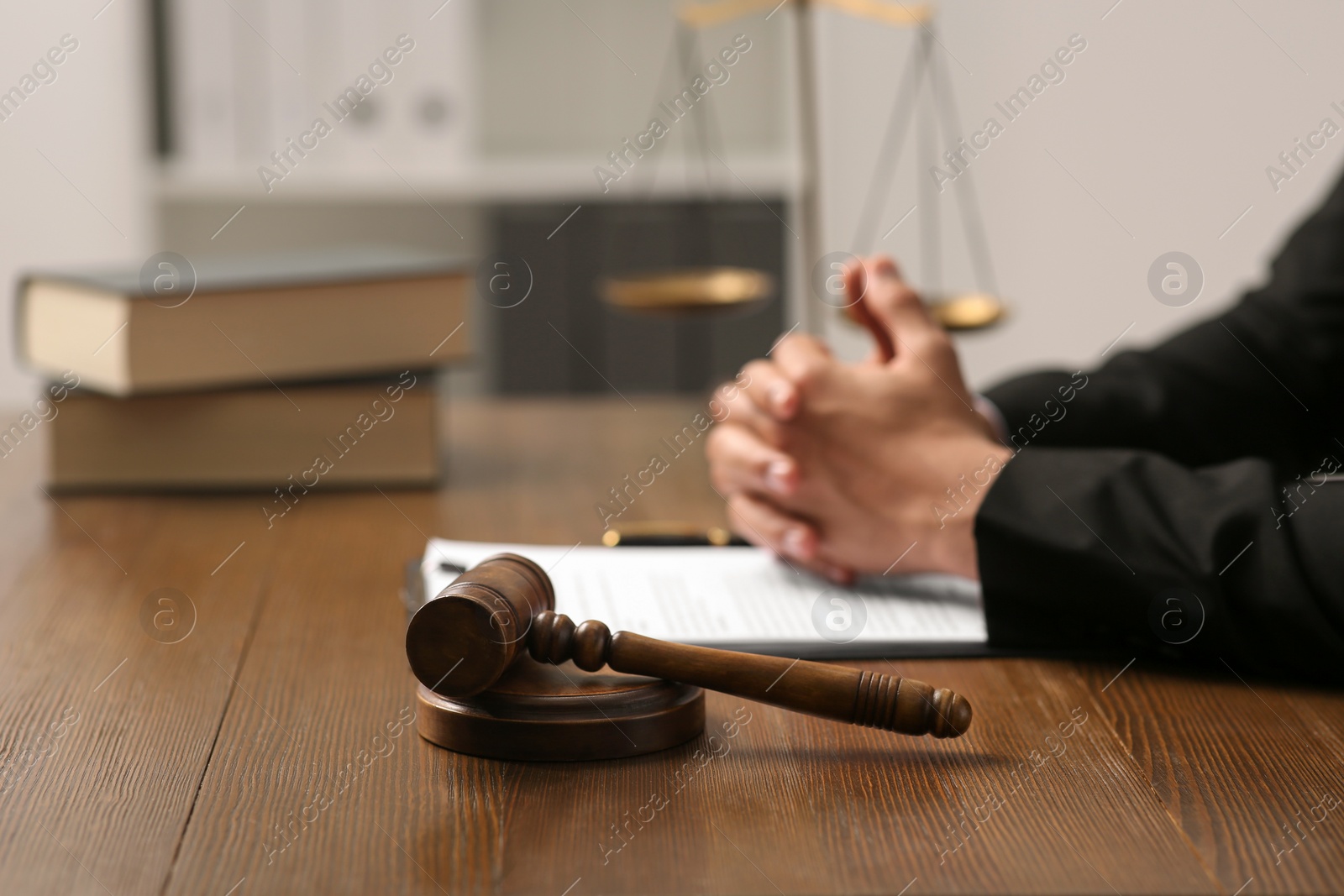 Photo of Law and justice. Closeup of judge at wooden table, focus on gavel