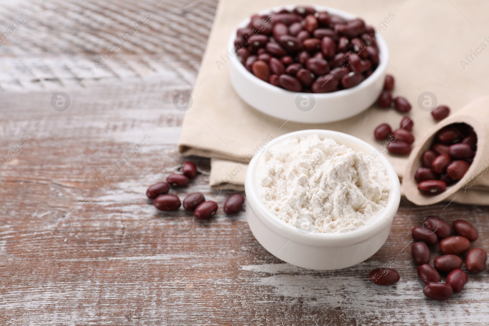 Kidney bean flour and seeds on wooden table. Space for text Photo of Kidney bean flour and seeds on wooden table. Space for text