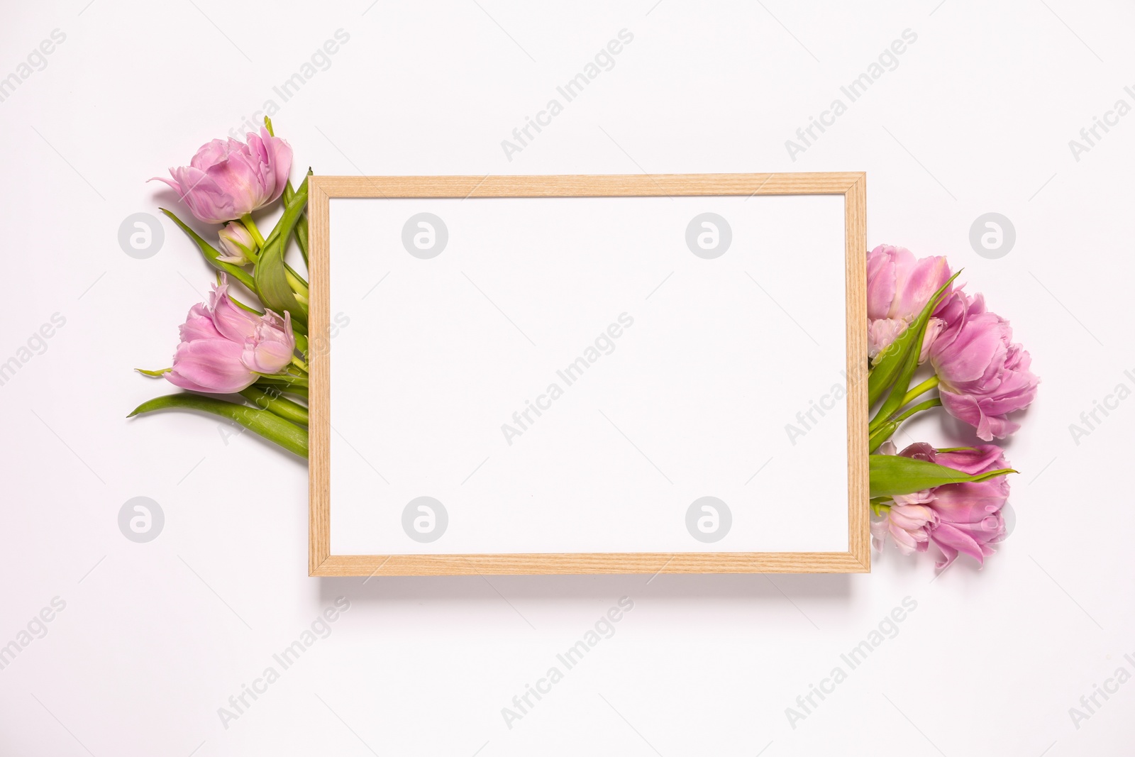 Photo of Empty photo frame and beautiful flowers on white background, top view. Space for design