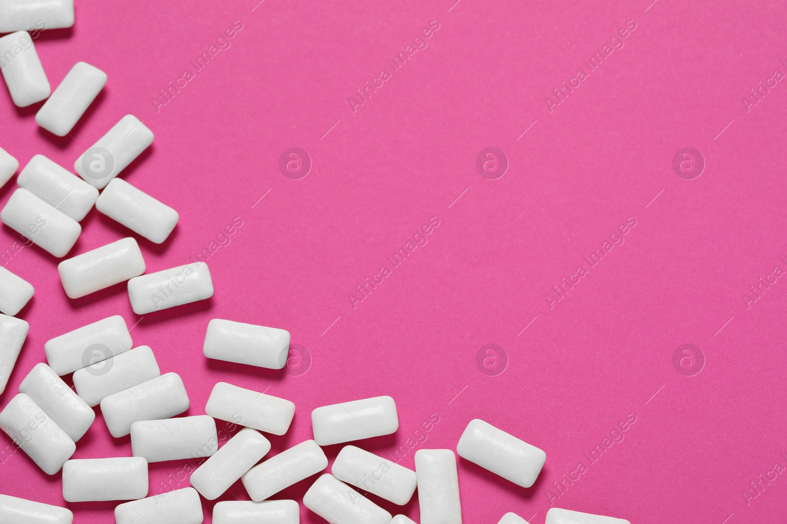 Photo of Tasty white chewing gums on pink background, flat lay