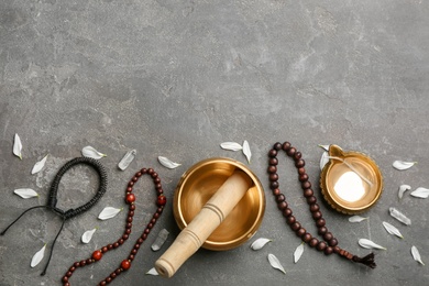 Photo of Flat lay composition with golden singing bowl on grey stone table, space for text. Sound healing