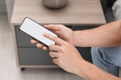 Photo of Man using mobile phone indoors, closeup view