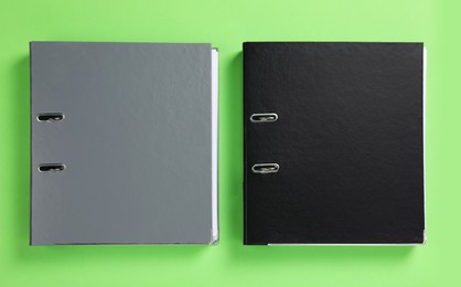 Office folders on light green background, flat lay