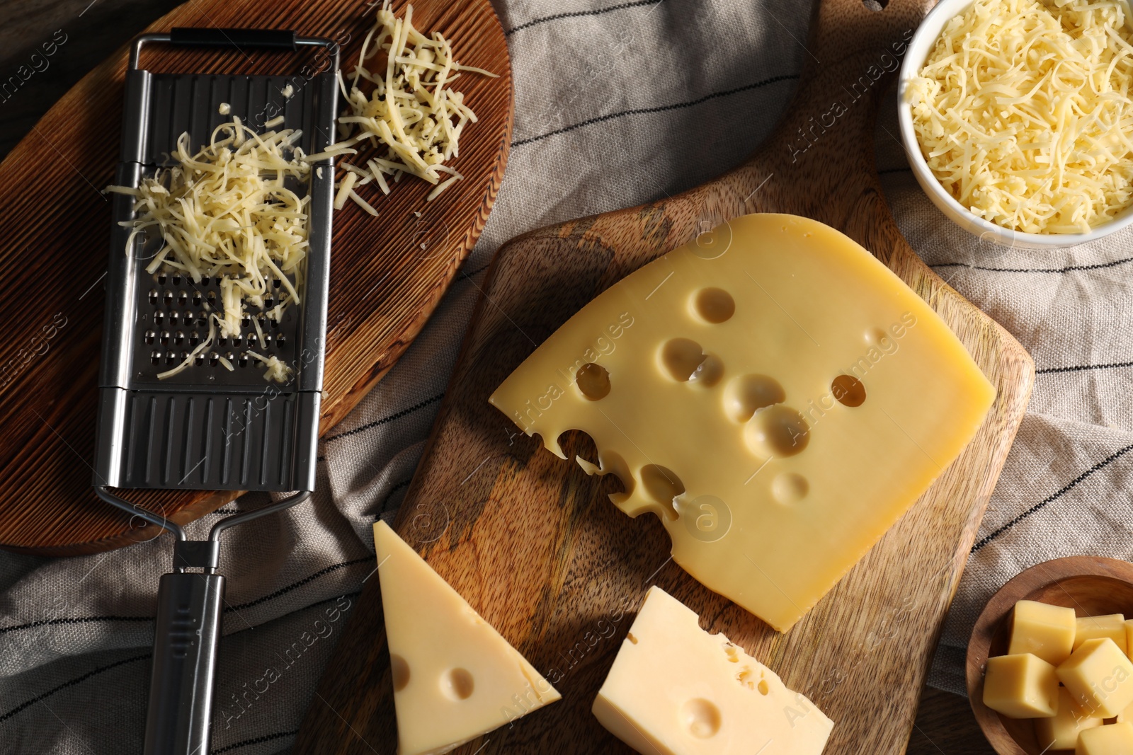 Photo of Grated, cut cheese and grater on table, flat lay