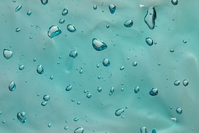 Photo of Turquoise facial gel as background, closeup view