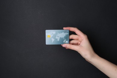 Photo of Woman holding credit card on black background, closeup