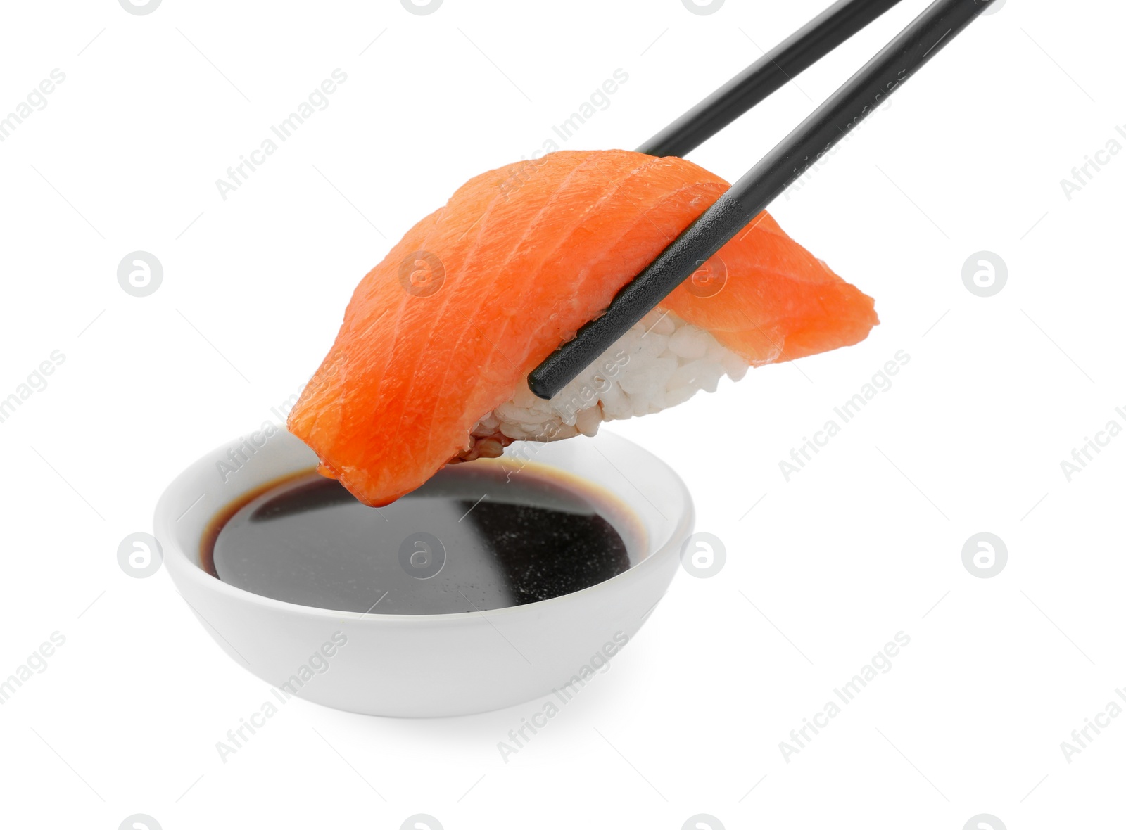 Photo of Dipping tasty sushi into soy sauce isolated on white