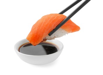 Photo of Dipping tasty sushi into soy sauce isolated on white