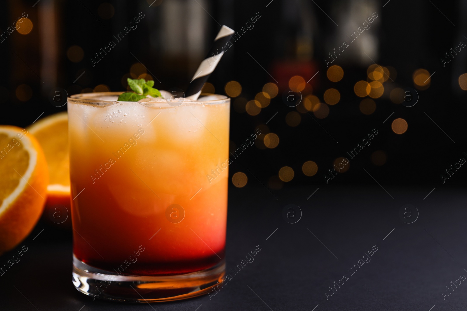 Photo of Fresh alcoholic Tequila Sunrise cocktail on grey table. Space for text