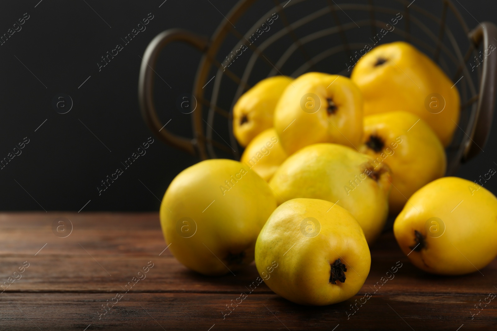 Photo of Delicious ripe quinces on wooden table, closeup. Space for text