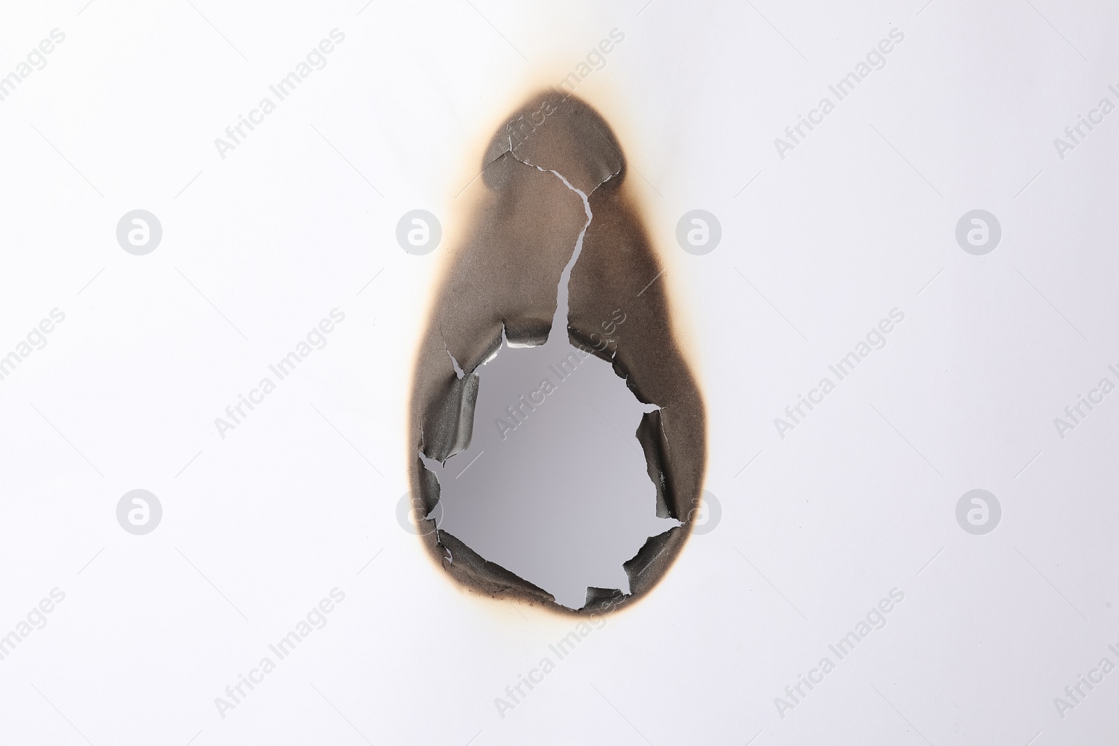 Photo of Burnt hole in paper on white background