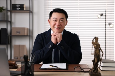 Photo of Happy notary working at wooden table in office