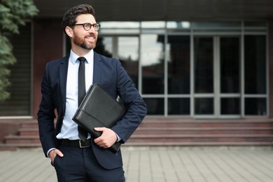 Handsome real estate agent with documents outdoors, space for text