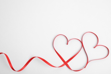 Photo of Hearts made of red ribbon on white background, top view. Valentine's day celebration