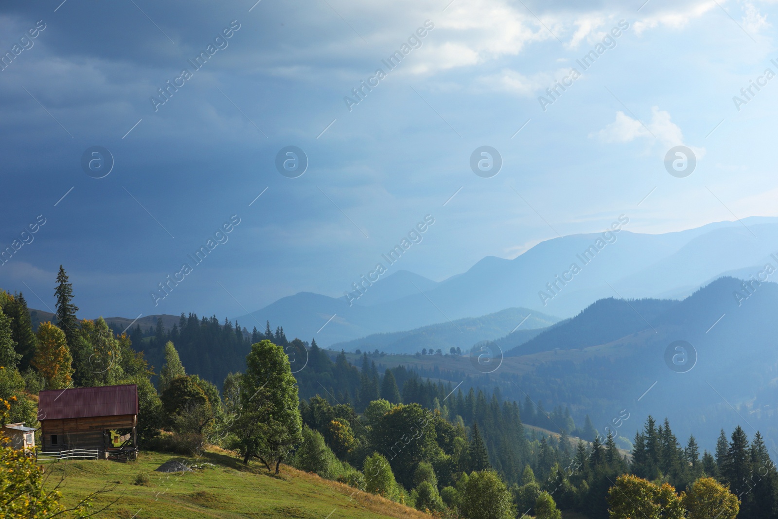 Photo of Beautiful view of wooden house on green hill in mountains