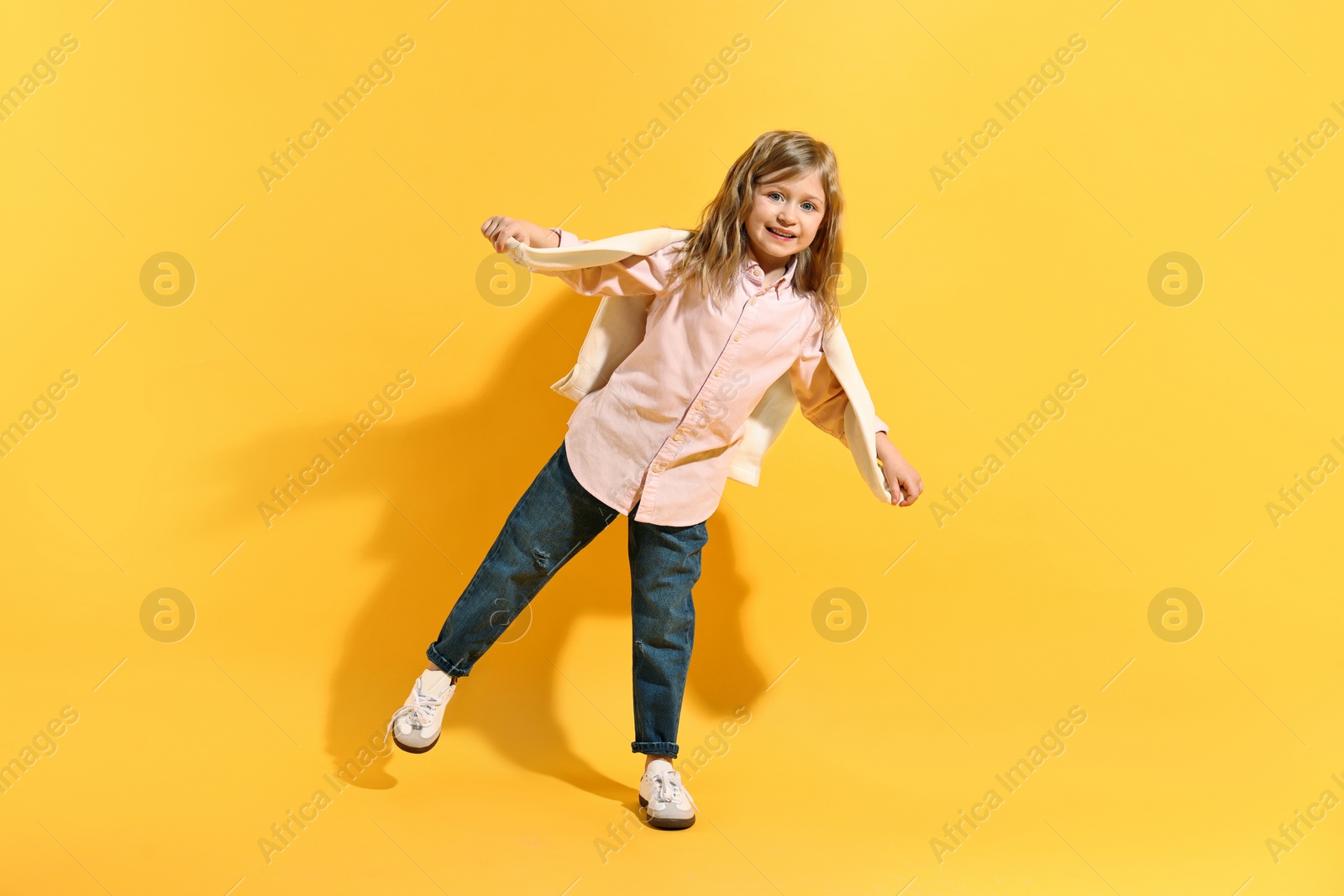 Photo of Fashion concept. Stylish girl posing on yellow background