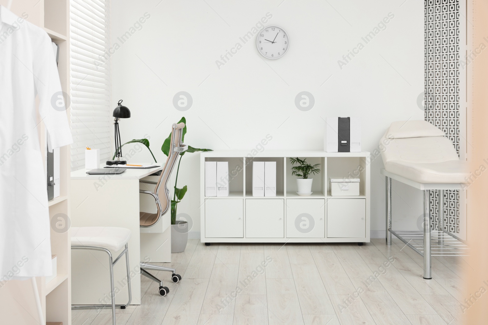 Photo of Modern medical office with doctor's workplace and examination table in clinic