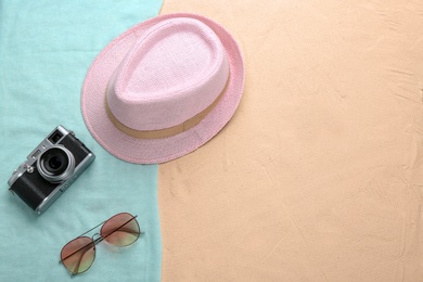 Photo of Flat lay composition with stylish hat, camera and sunglasses on sand