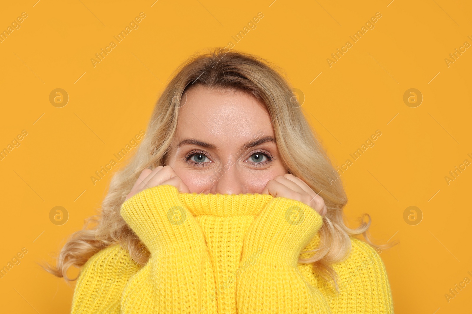 Photo of Beautiful woman in stylish warm sweater on orange background