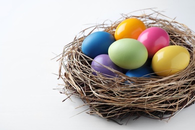 Photo of Bright painted eggs on white wooden table, closeup view with space for text. Happy Easter